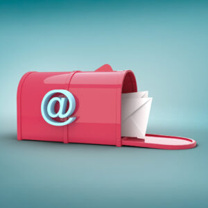 Obraz przedstawia otwartą skrzynkę pocztową czerwona a na niej znak @