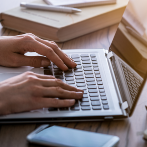 Ręce piszące na klawiaturze laptopa